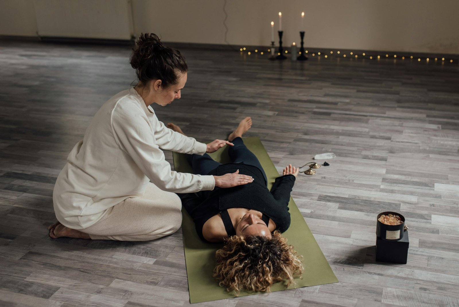 A serene indoor setting capturing a therapist using Reiki techniques on a client.