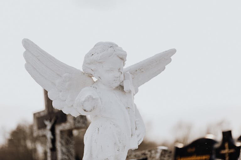 A serene stone angel statue photographed outdoors, symbolizing peace.