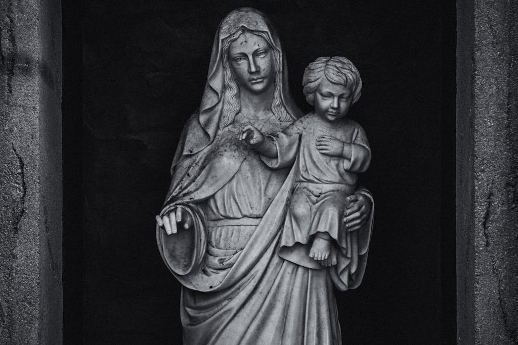 Dramatic grayscale close-up of a sacred marble statue depicting Madonna and Child, embodying faith and serenity.
