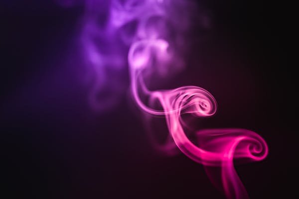 A stunning abstract image of swirling purple and pink smoke on a dark background.